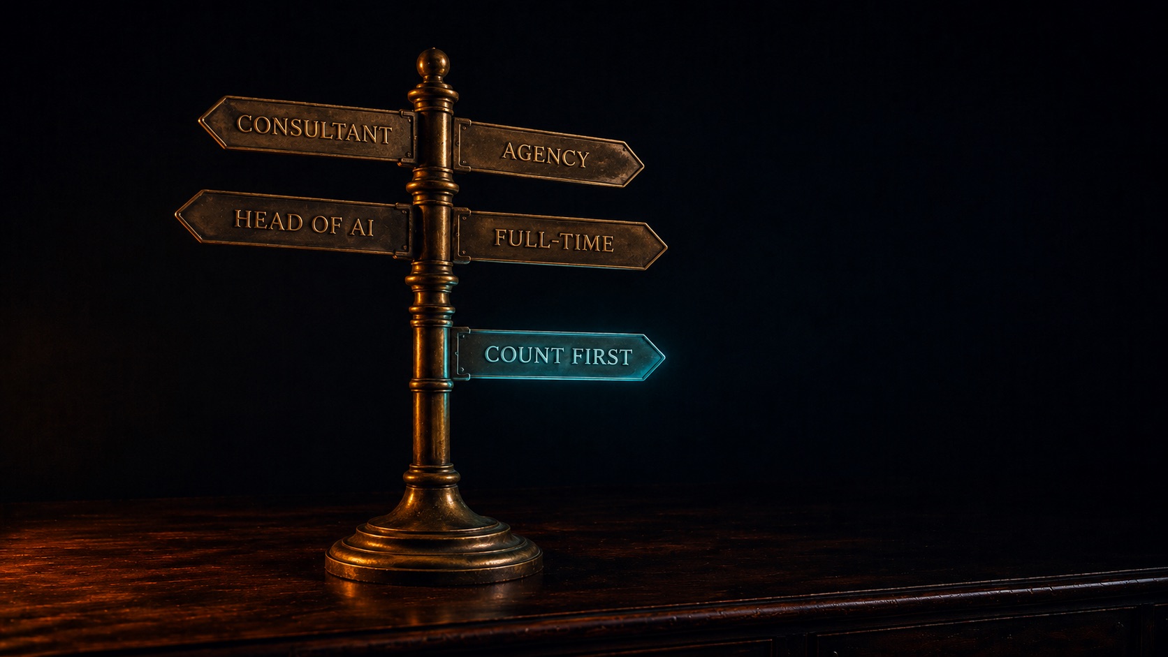 A small antique brass fingerpost on a dark desk. Four brass signs point different ways, engraved Consultant, Agency, Head of AI, and Full-time; a fifth sign set lower and apart glows teal and reads Count First.